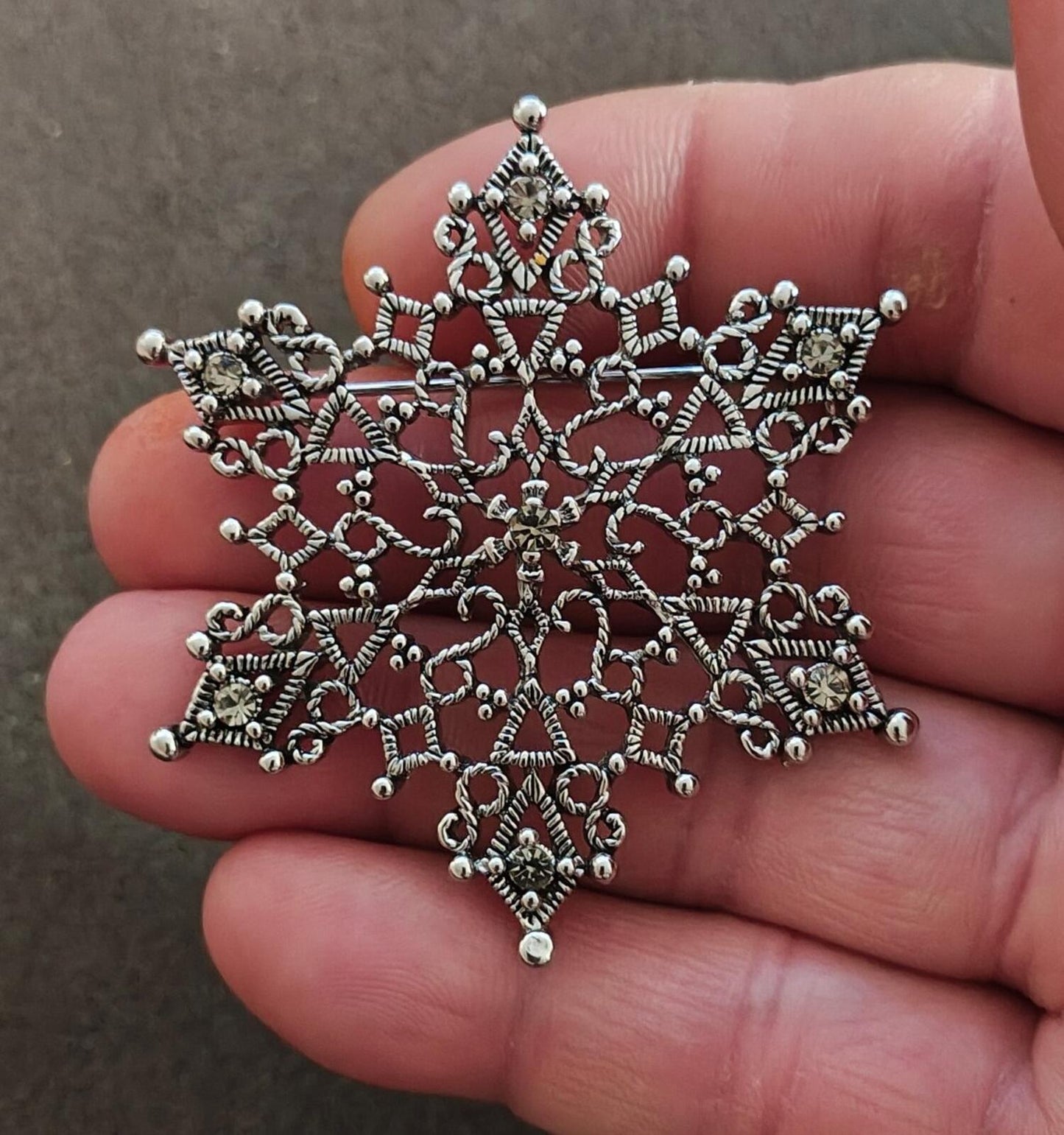 1990s Silver Tone Filigree Snowflake With Clear Rhinestone Accents Brooch.