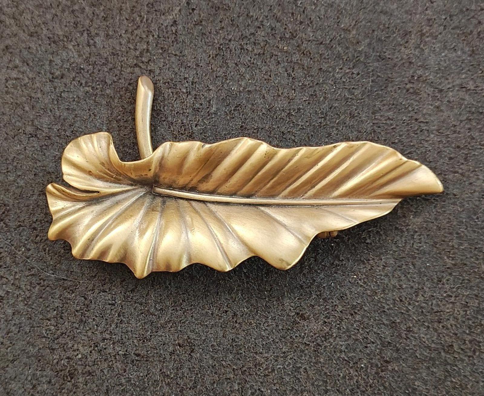 Gold-tone leaf brooch pin with detailed leaf veins and raised center ridge.