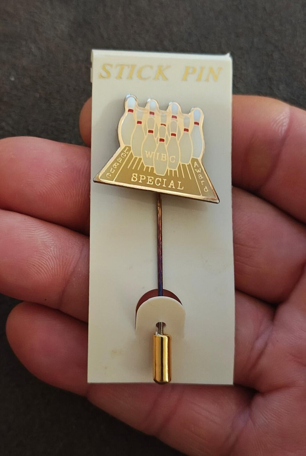 Gold tone stick pin with baseball glove and “SPECIAL” plaque on display card
