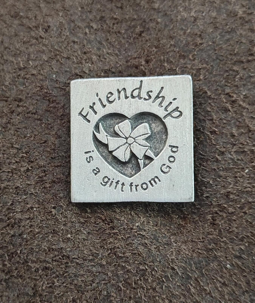 Silver square pin with engraved heart, flower, and friendship text