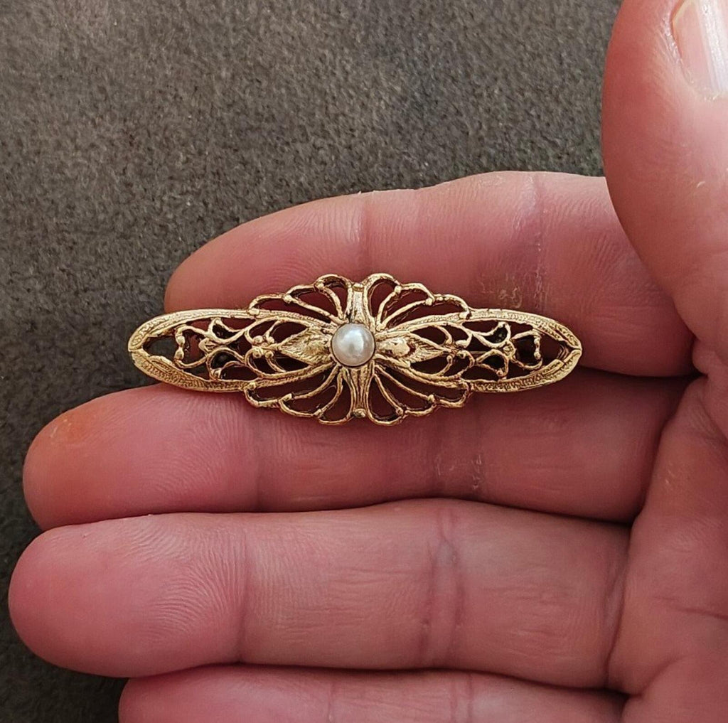 Gold-tone ornate bar brooch with central faux pearl and Victorian filigree design