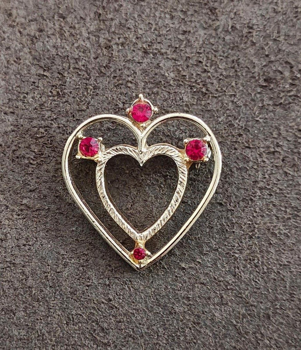 Gold-tone heart brooch pin with red rhinestone accents, full front view