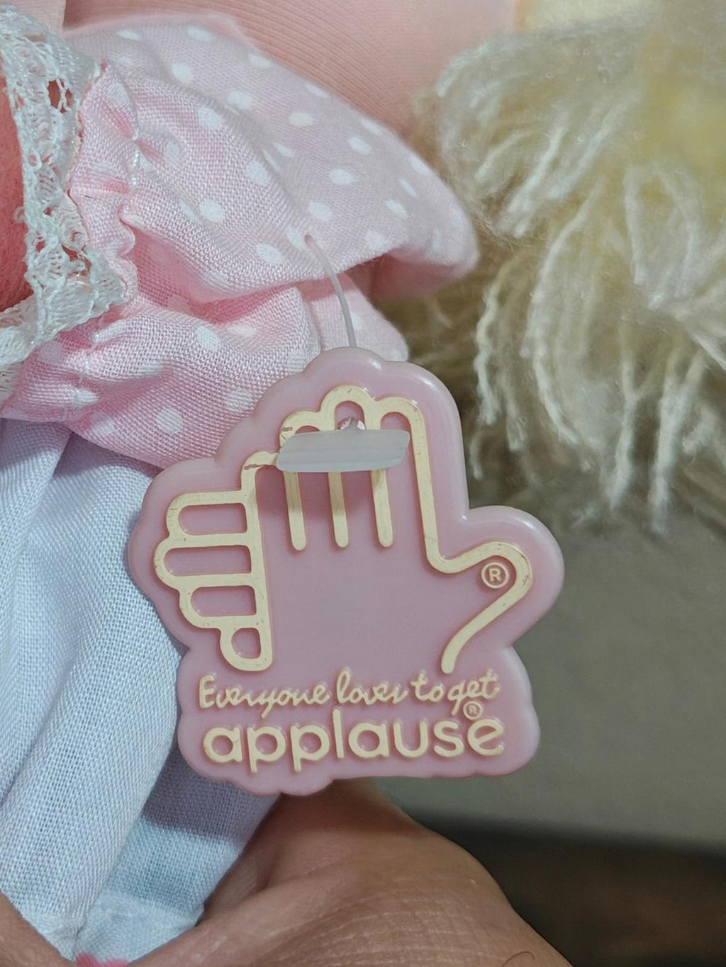 Heart-shaped plastic charm tag reading “Everyone loves to get applause”