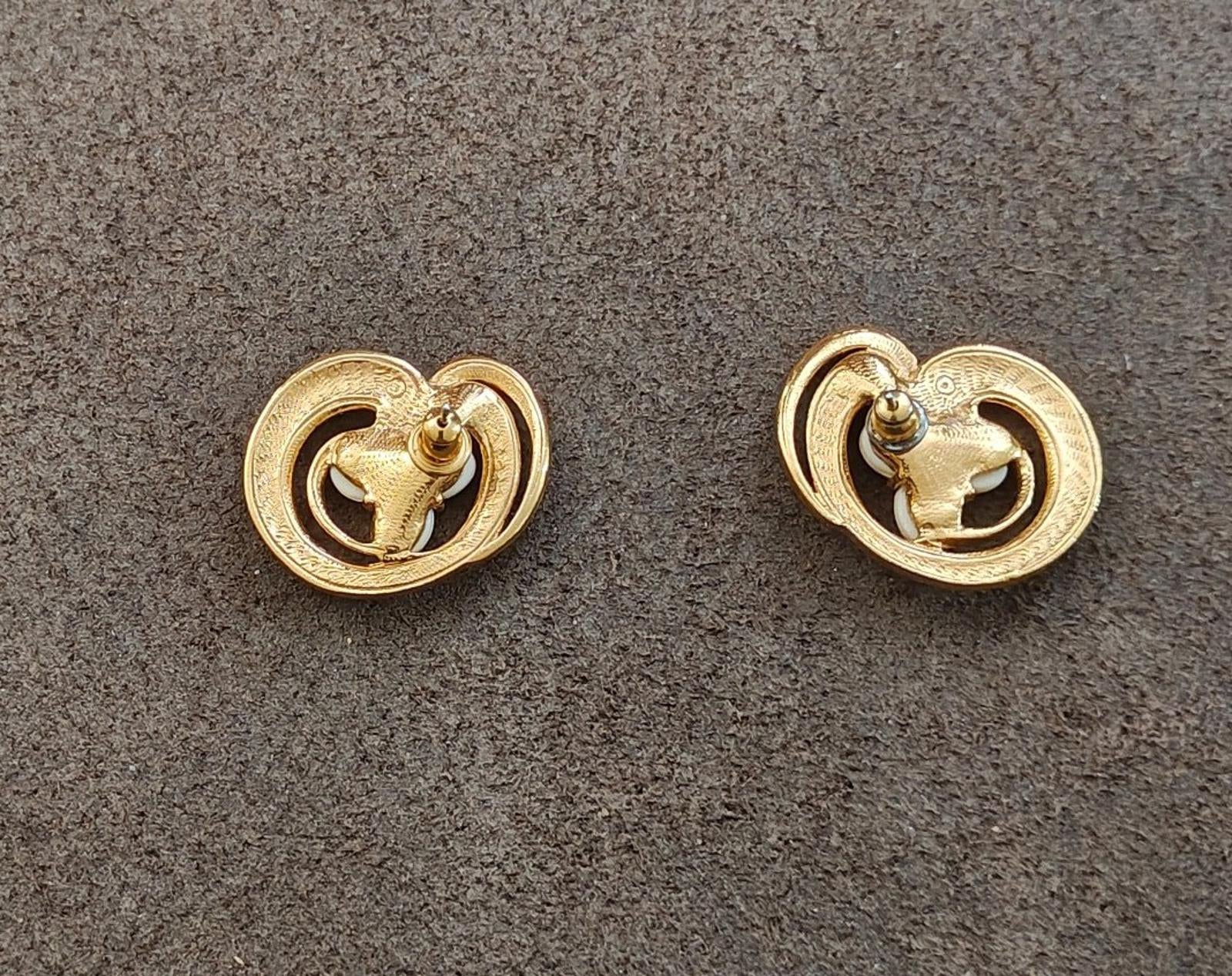 Gold tone clip-back of heart-shaped earrings with hinged clasp, showing hardware detail