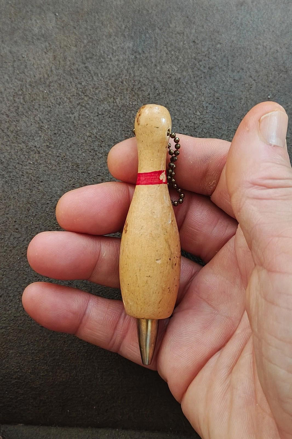 Beige wooden bowling pin keychain pencil with red band, bead chain, and metal tip