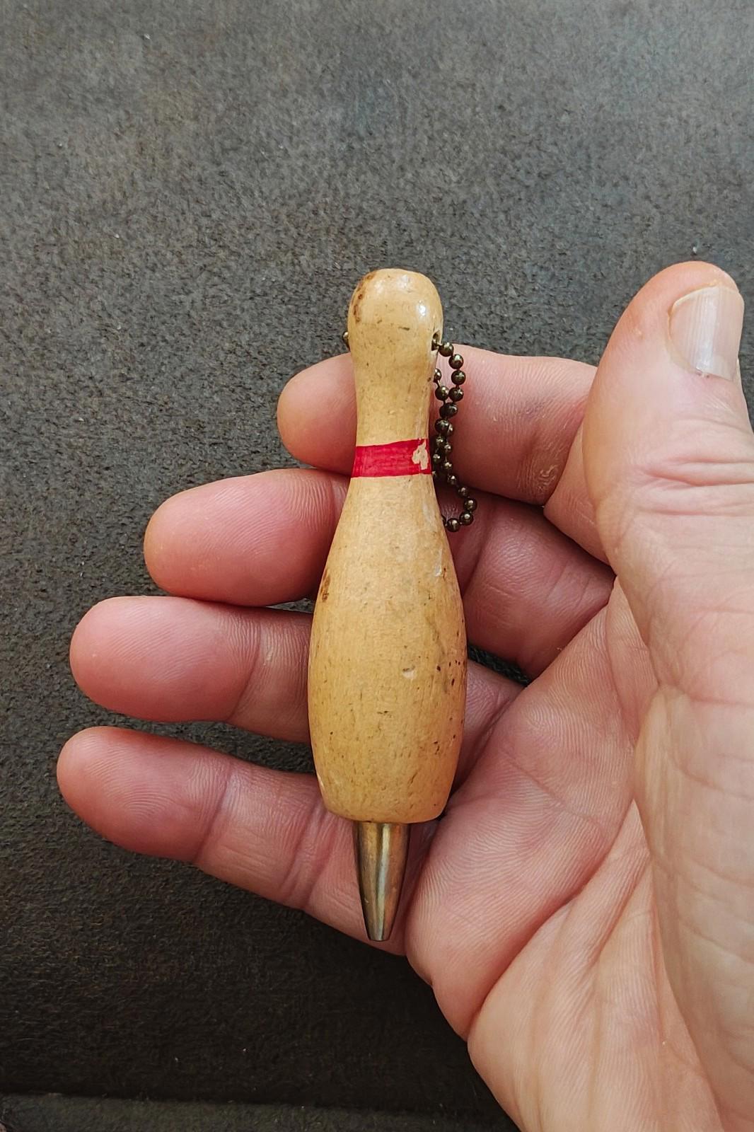 Beige wooden bowling pin keychain pencil with red band, bead chain, and metal tip