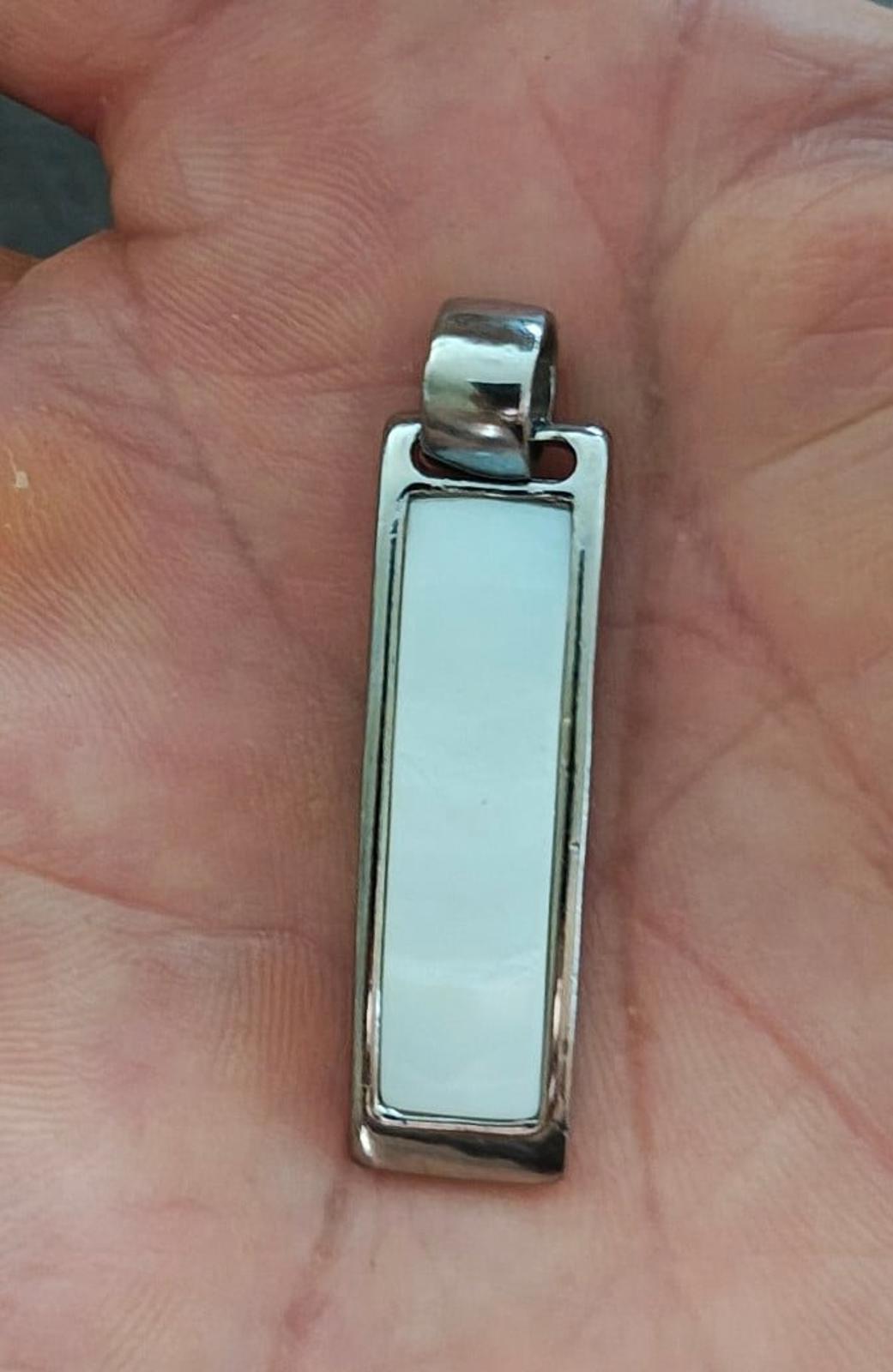 Silver-tone rectangular slide pendant with light white/blue inlay window on front.