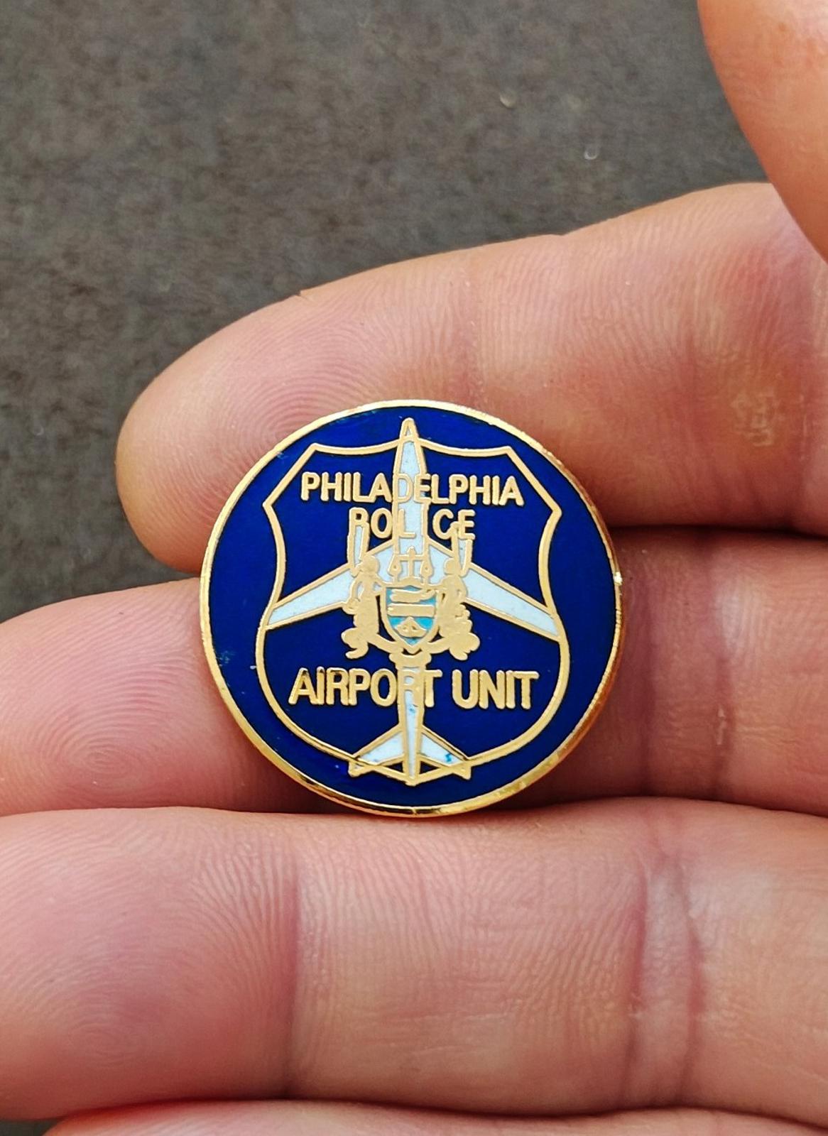 Close-up of round blue enamel Philadelphia Police Airport Unit lapel pin with gold trim