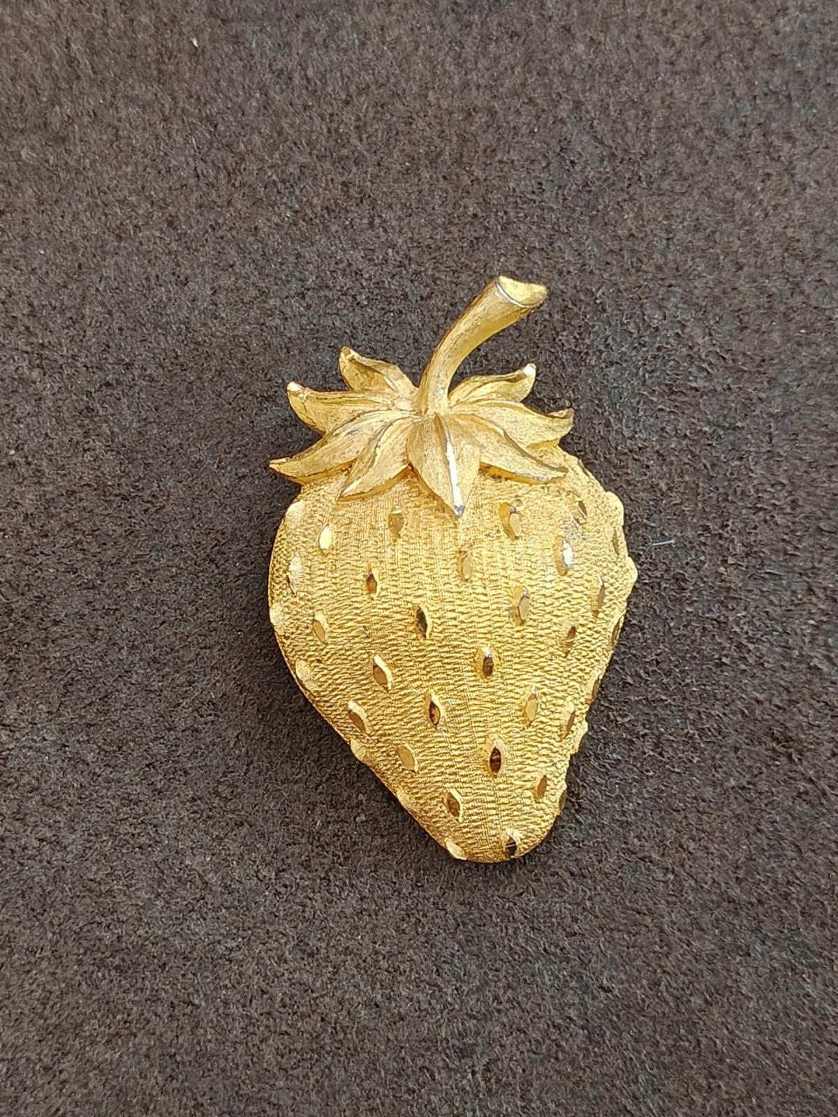 Gold tone strawberry brooch pin, front view with leaf and dotted seed detail.