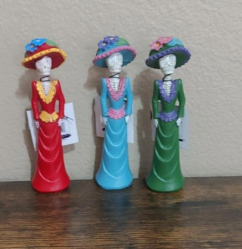 Set of three Day of the Dead lady figurines in red, blue, and green dresses, front view