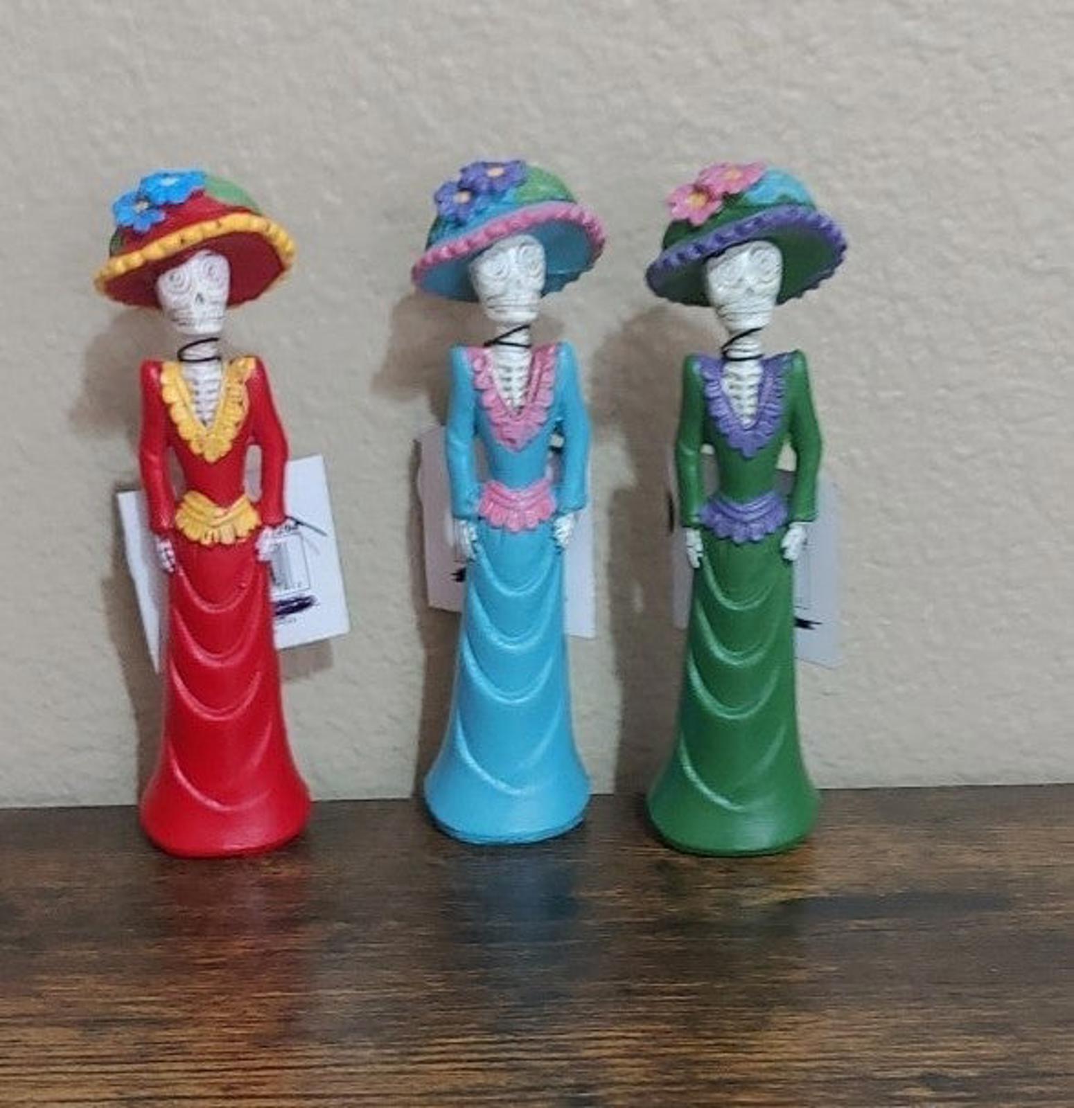 Set of three Day of the Dead lady figurines in red, blue, and green dresses, front view