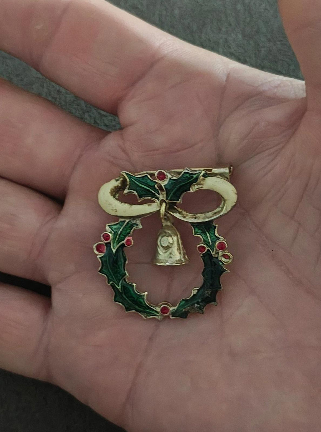 Green enamel Christmas wreath brooch with red berry accents, gold bell centerpiece