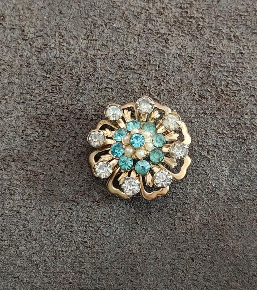 Gold-tone floral sunburst pin with teal cluster and faux pearls, ringed with clear rhinestones