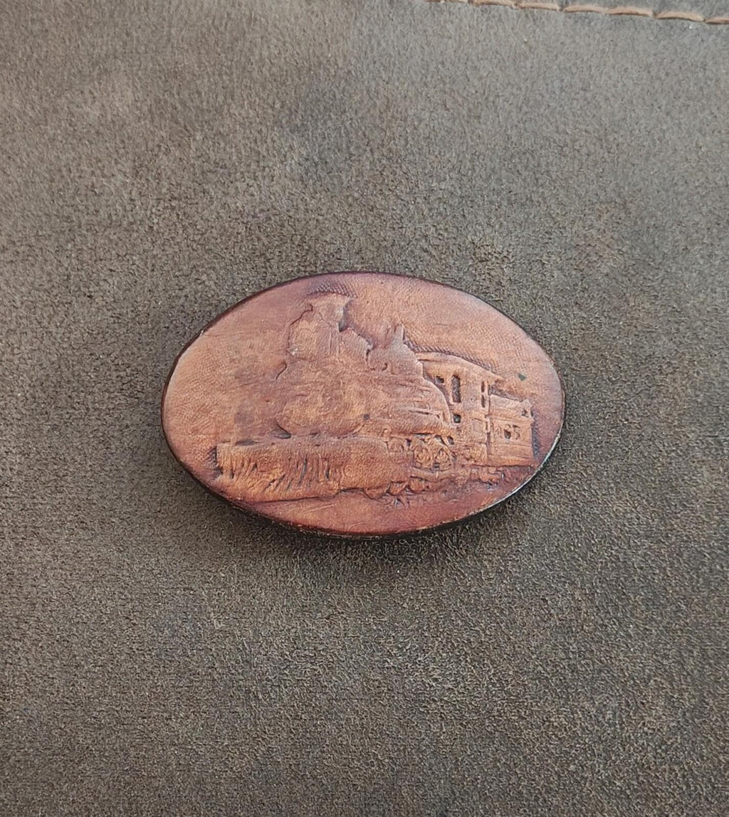 Brown oval leather belt buckle with steam locomotive emboss detail