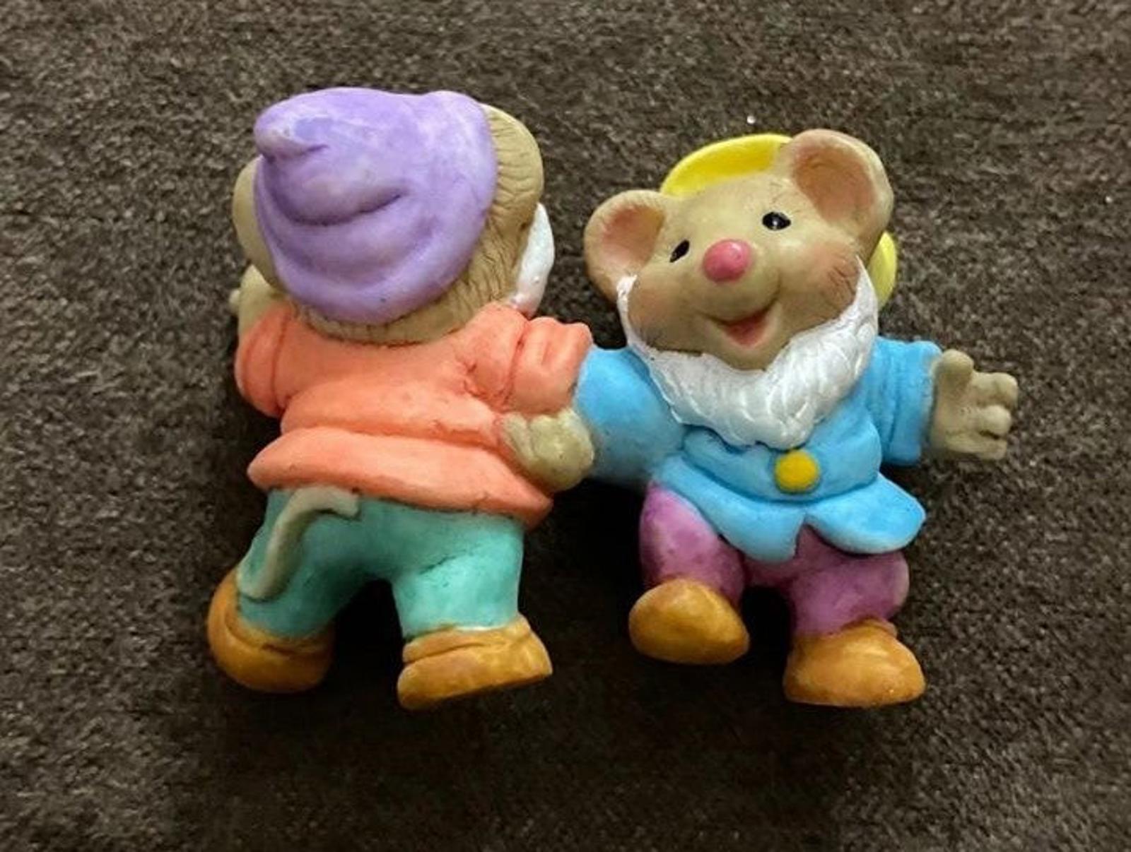 Two dwarf figurines with purple hat and orange clothing, facing opposite directions.