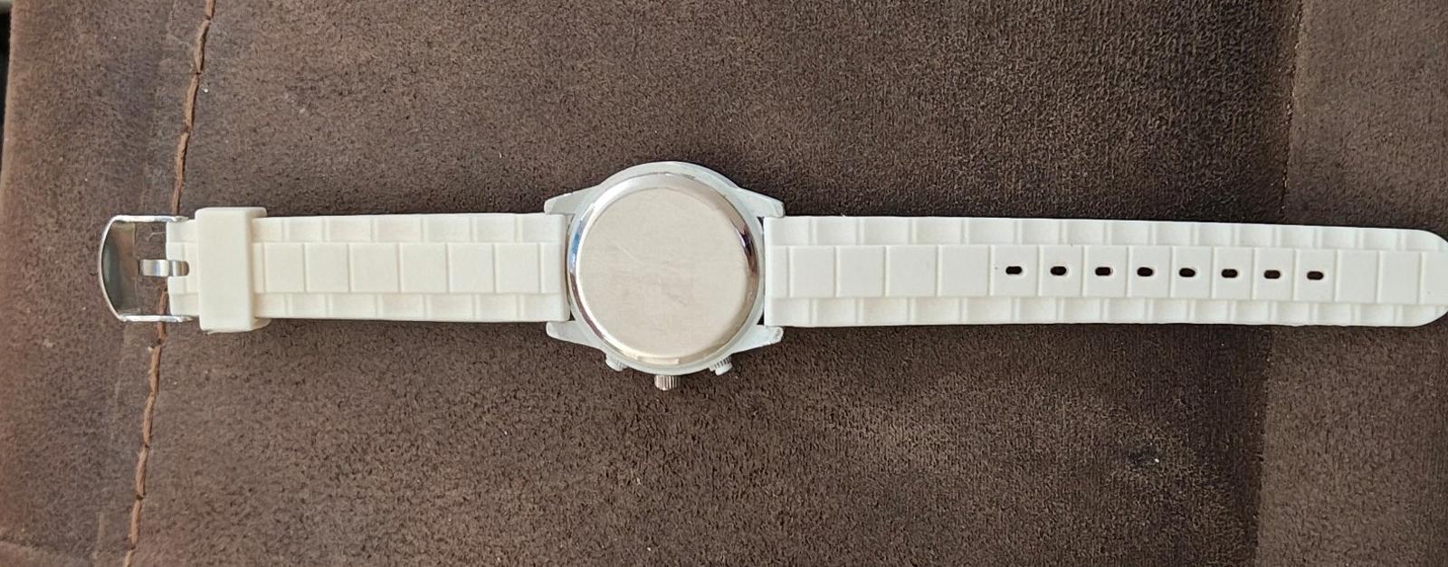 White silicone watch band shown from the side with clasp and rounded case profile