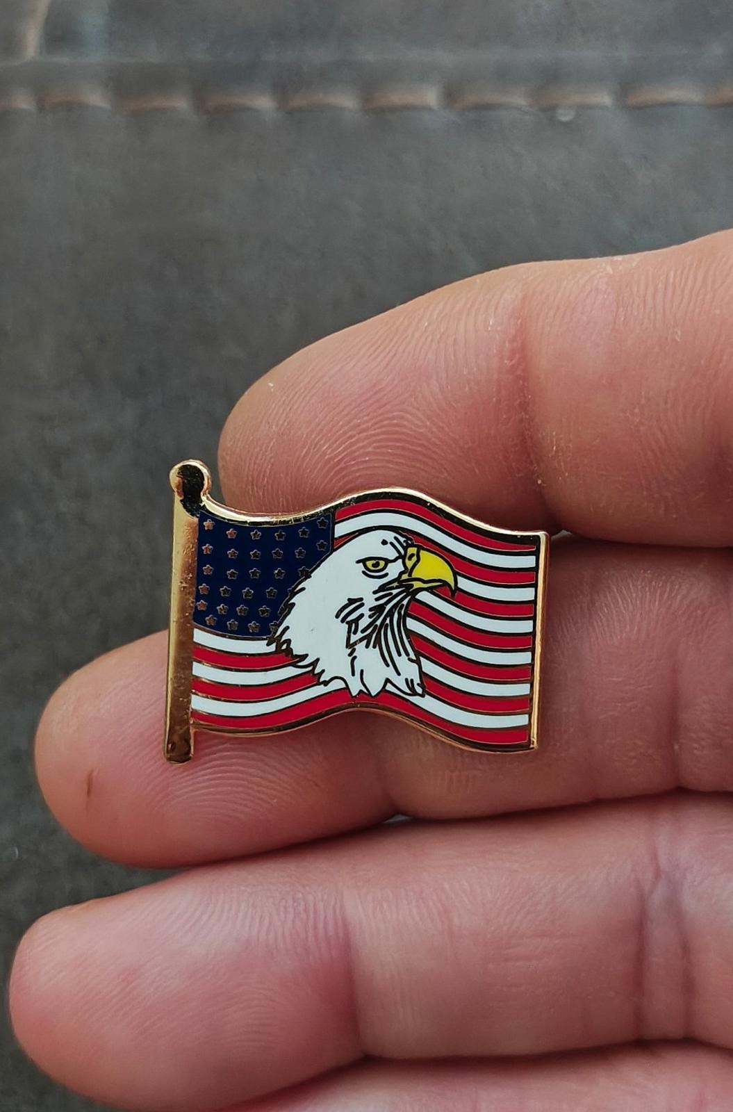 Gold-tone enamel wavy American flag lapel pin with bald eagle, close-up