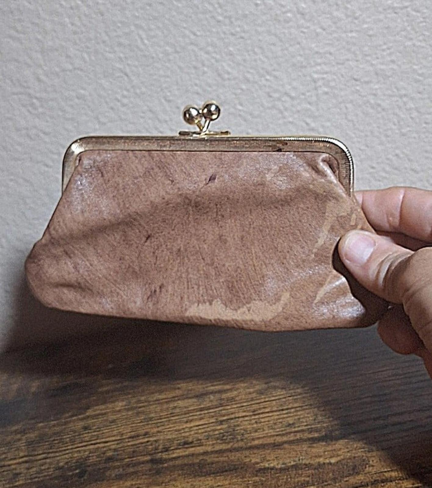 Tan leather coin purse wallet with metal frame and kiss-lock clasp, back view.