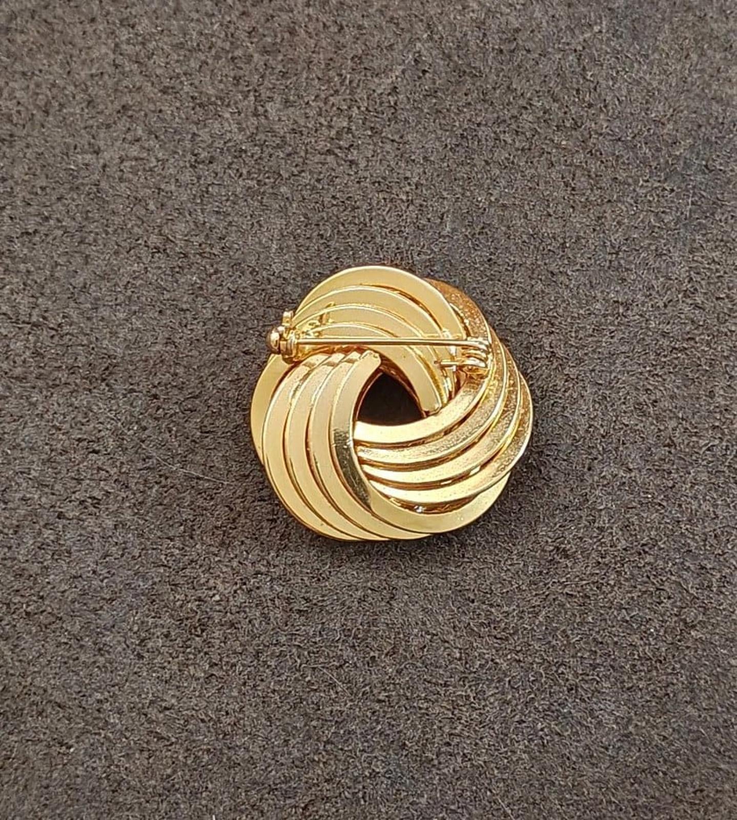 Gold tone back of swirl brooch pin with pin stem and clasp mechanism