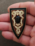 Gold tone Art Deco shield brooch with black stone and clear rhinestones on black enamel
