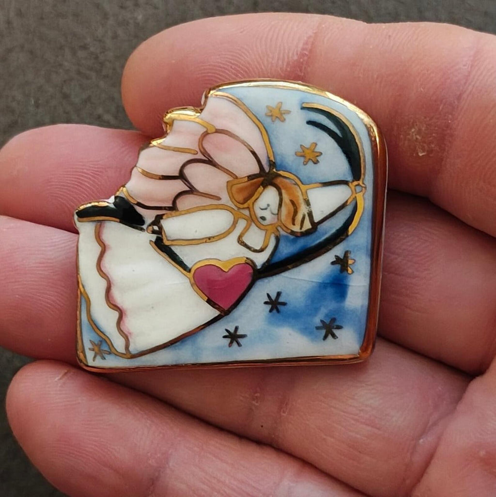 Gold-tone enamel angel brooch with blue moon, stars, and pink heart held in hand