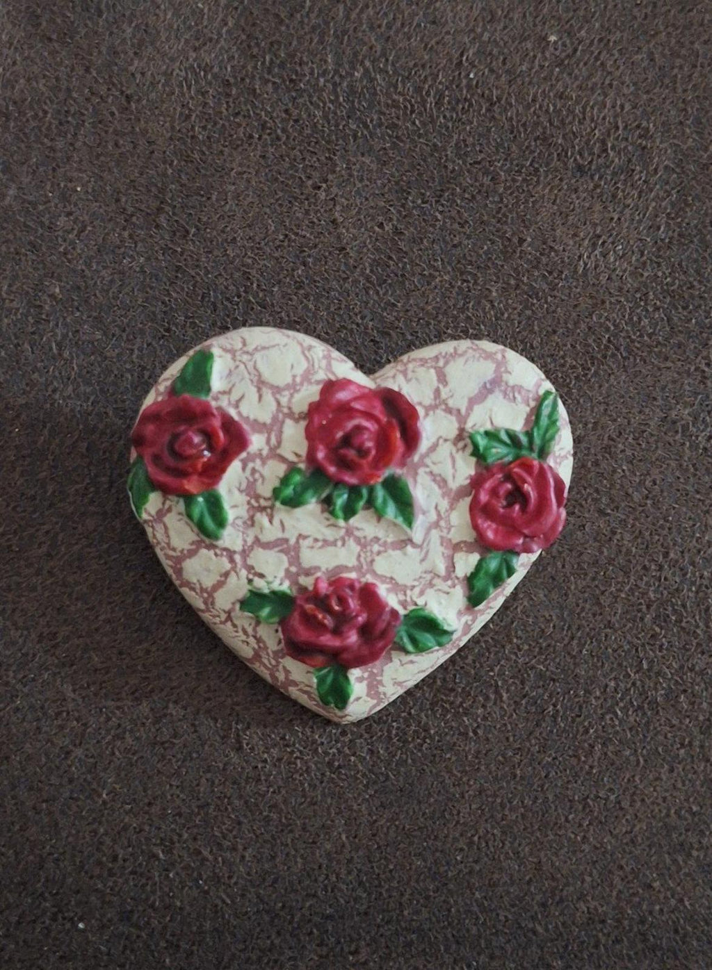 Heart-shaped resin pin featuring red roses with green leaves on a crackled white background
