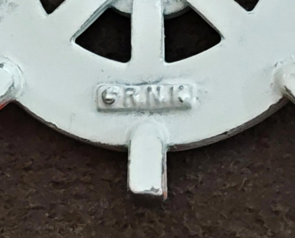 R.N.K. hallmark on back of white ship's wheel enamel brooch