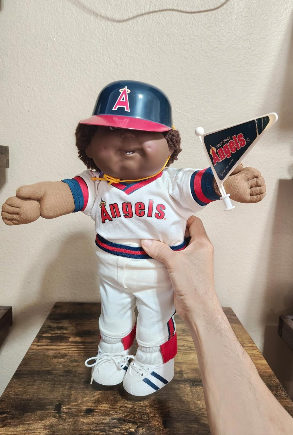 Baseball uniform doll with dark blue helmet and white Angels jersey, holding bat