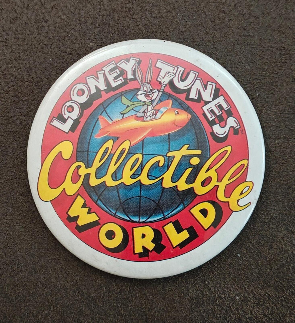 Round Looney Tunes “Collectible World” button pin featuring globe, rocket character, and bold text.