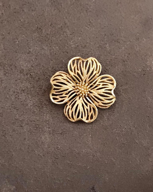 Gold-tone dogwood flower brooch with textured petals and beaded center