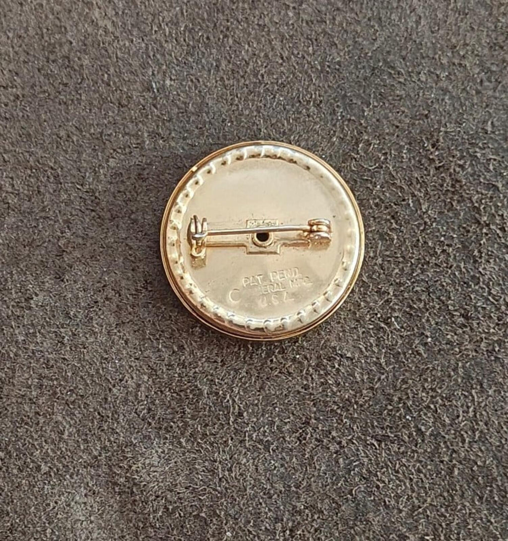 Gold-tone round brooch back with hinged pin and maker markings