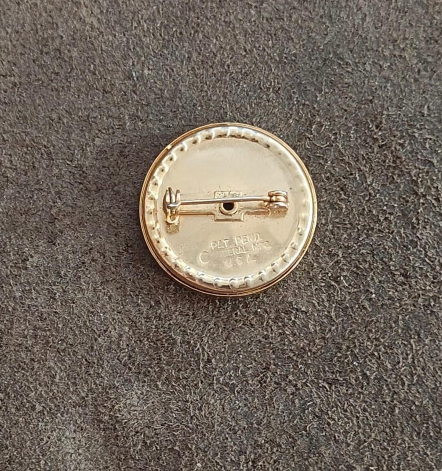 Gold-tone round brooch back with hinged pin and maker markings