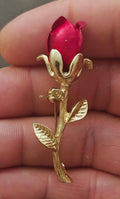 Gold tone red enamel rosebud brooch with single stem and leaf details