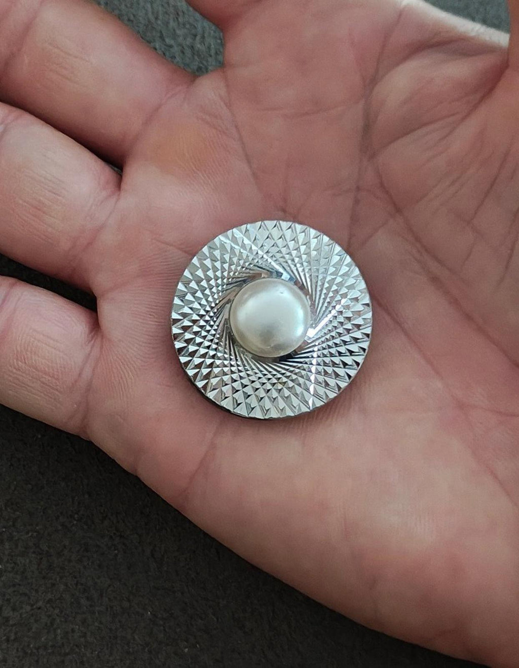 Round silver-tone scarf clip with textured rim and domed faux pearl front
