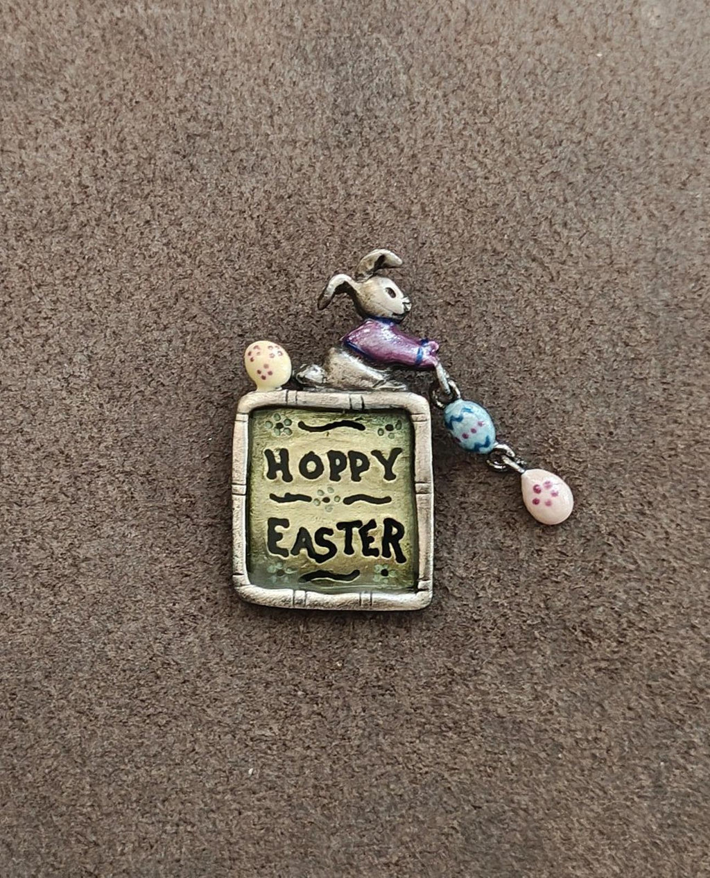 Pewter “Hoppy Easter” brooch pin featuring a sitting rabbit and dangling pastel egg charms