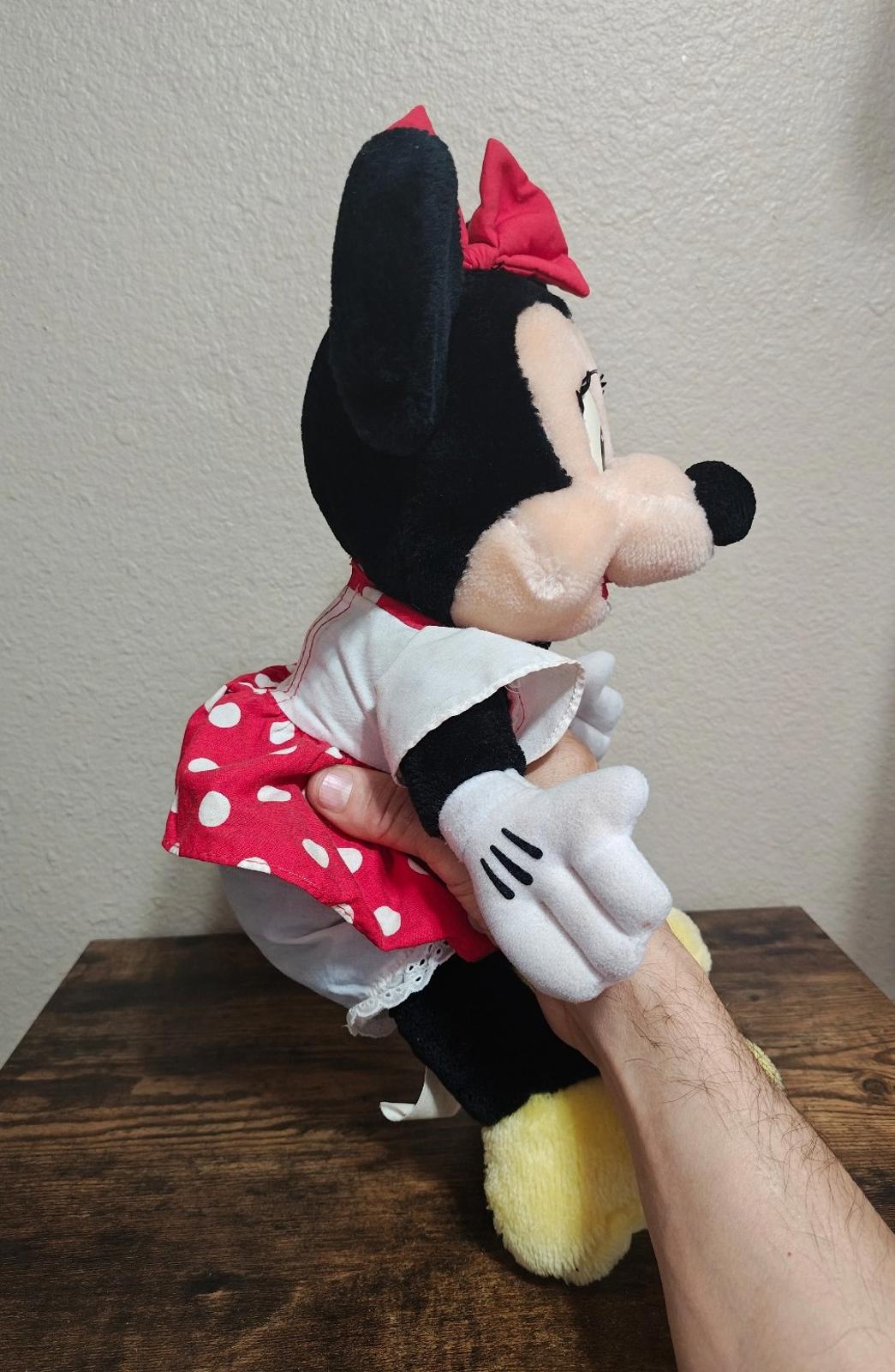 Minnie Mouse plush side view with red bow, red polka-dot dress, white gloves, yellow feet
