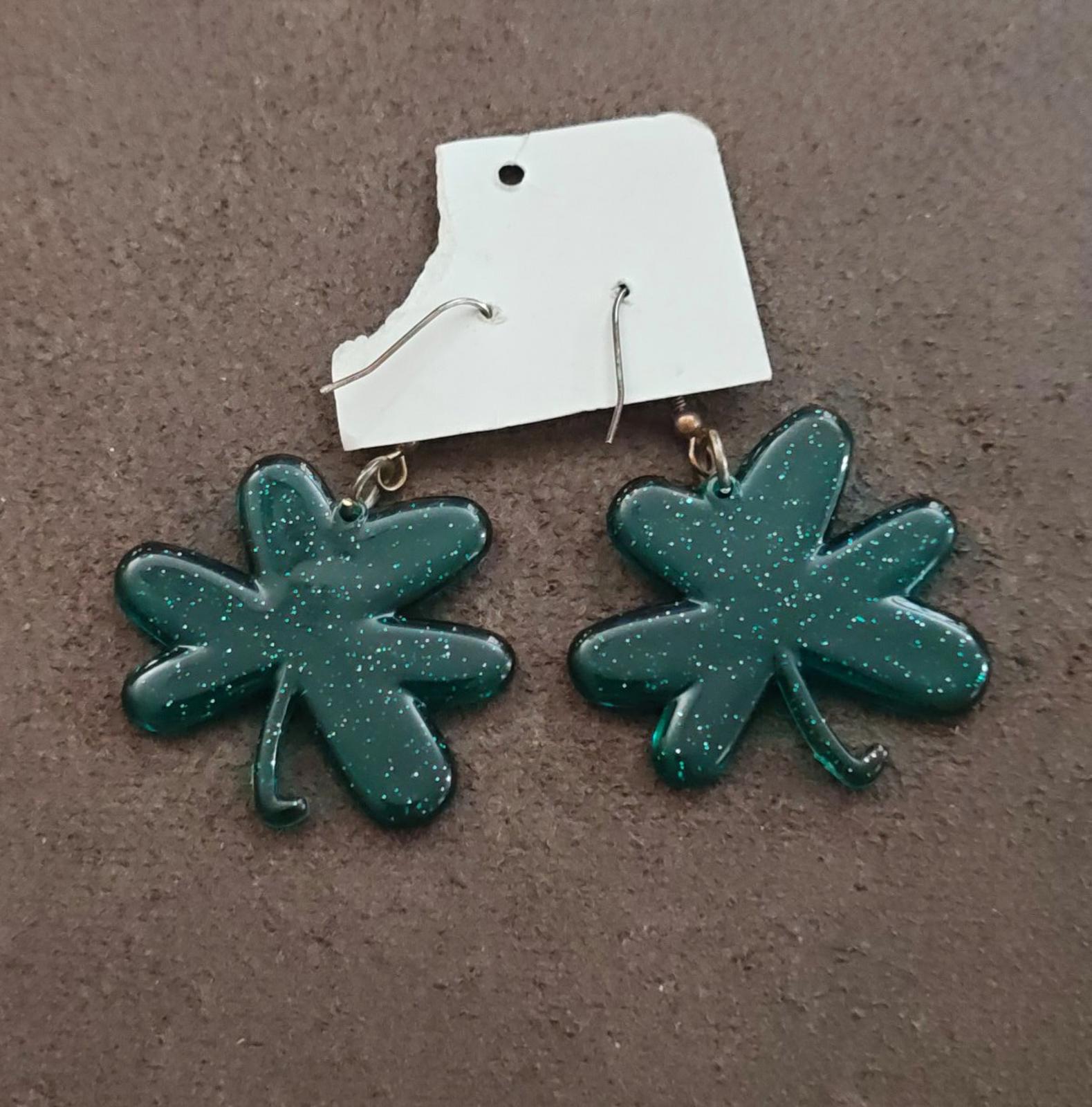Pair of green glitter shamrock earrings on hooks with small bronze accents