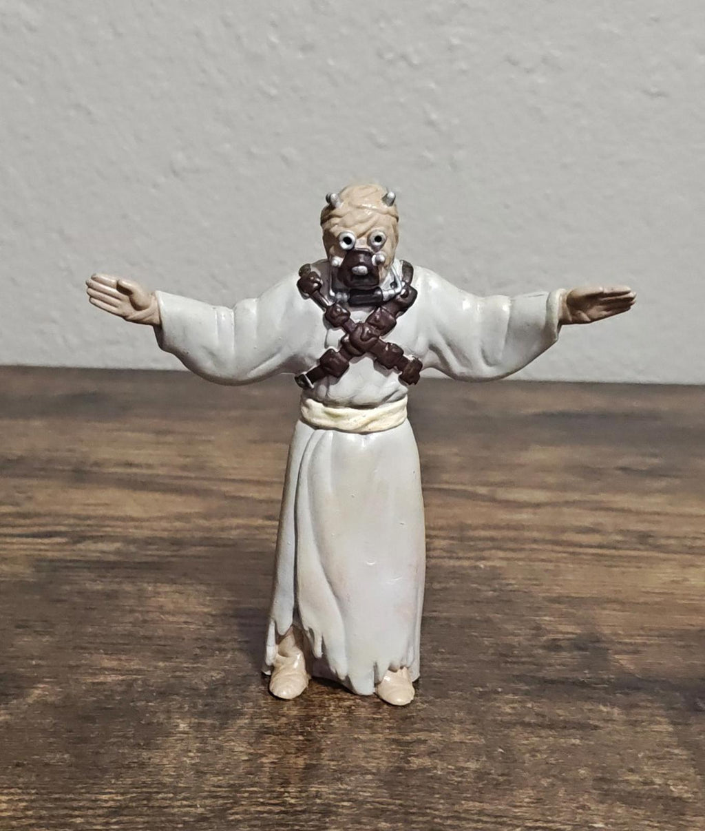 Bendable Tusken Raider action figure in white robe with brown harness, full body, arms out