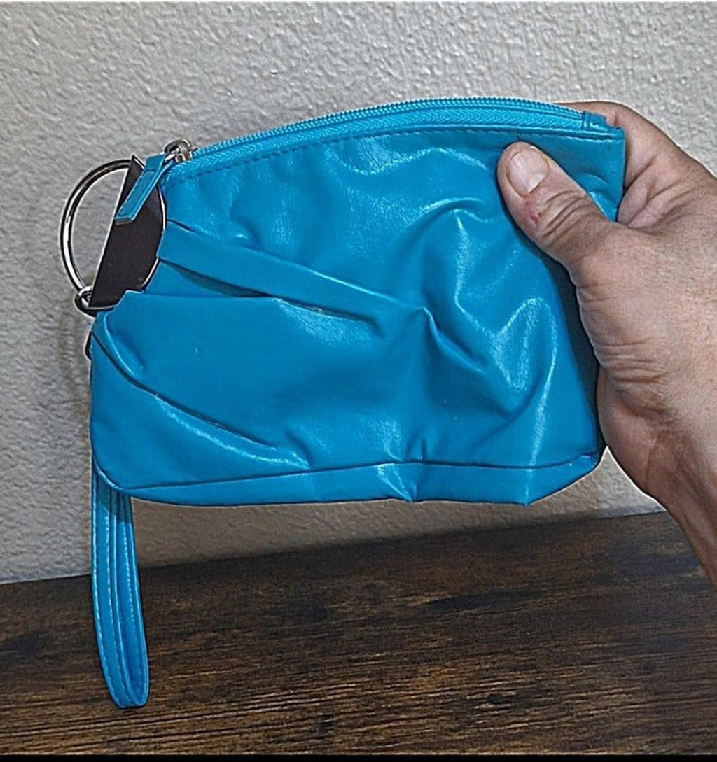 Teal PVC clutch purse with zipper top and wrist strap, shown from side