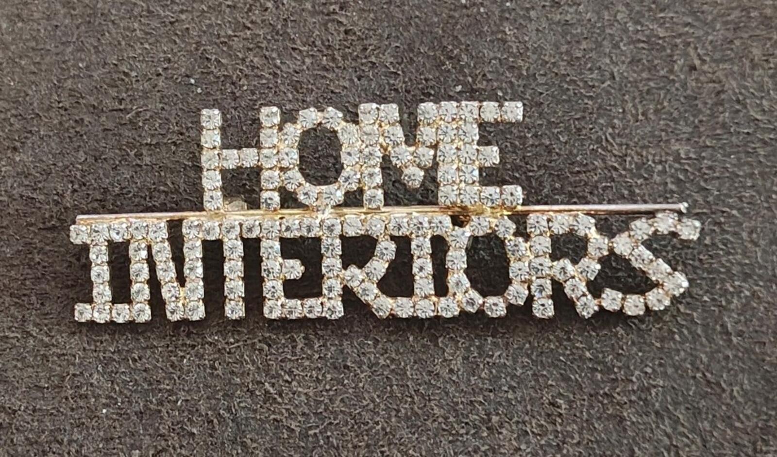 Rhinestone gold-tone brooch spelling "HOME" and "INTERIORS"