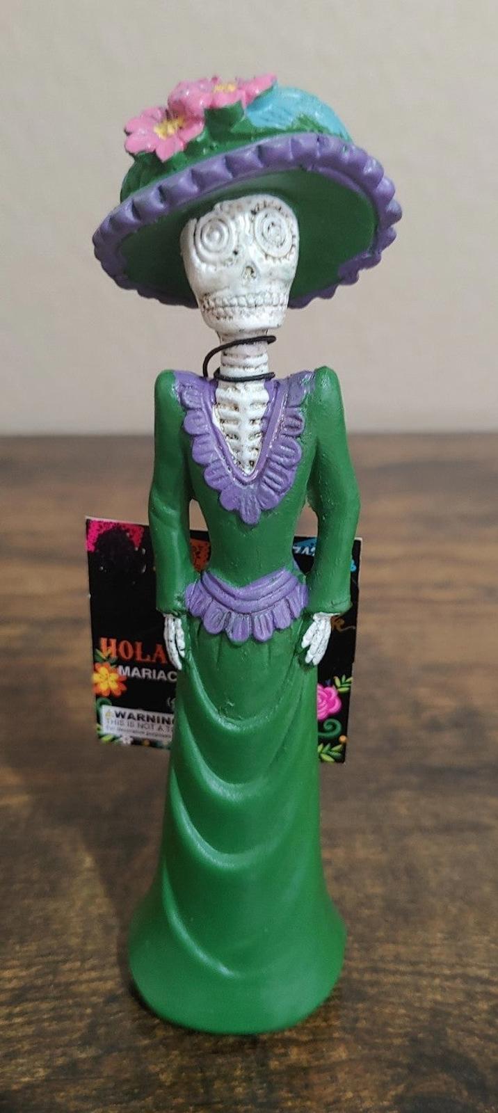 Day of the Dead lady figurine with sugar skull face, green dress and decorated sombrero