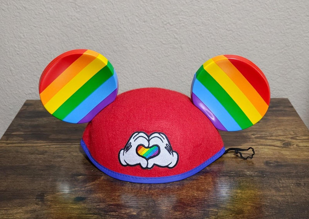 Red felt Mickey Mouse ear hat with rainbow-striped ears and heart-love graphic