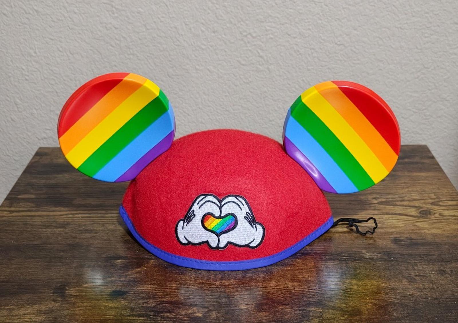 Red felt Mickey Mouse ear hat with rainbow-striped ears and heart-love graphic