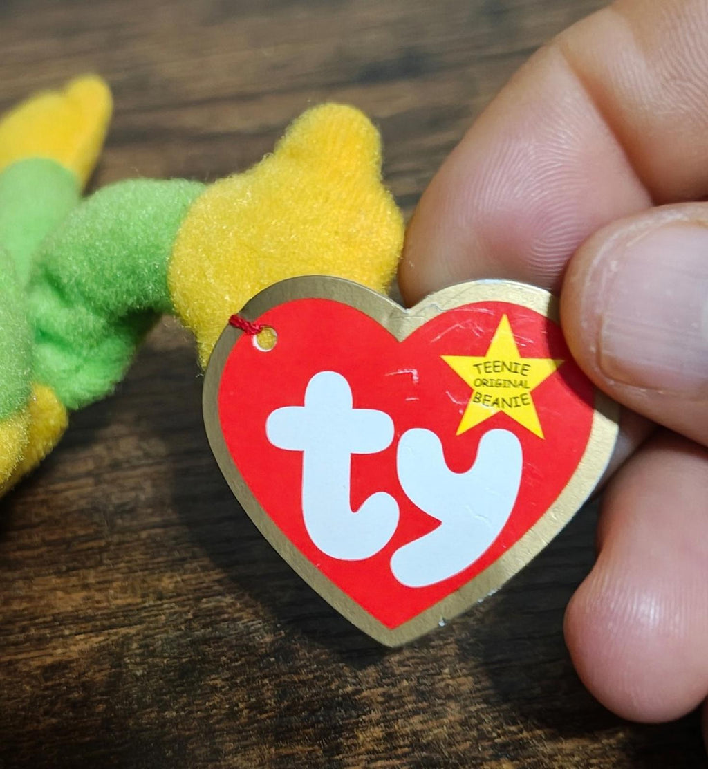 Red and gold heart Ty tag attached to green frog plush