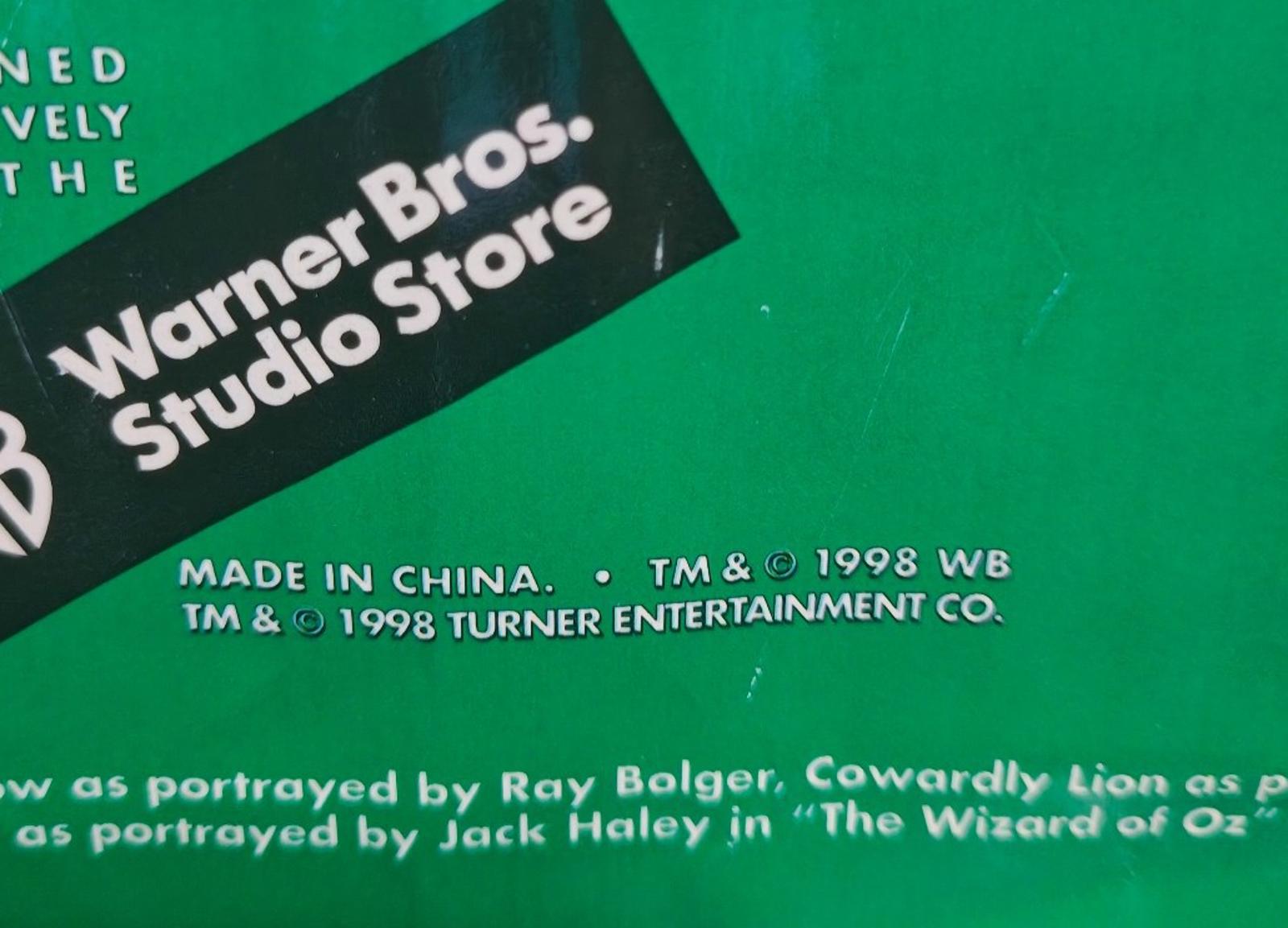 Green paper shopping bag detail with Warner Bros Studio Store logo and made-in-China text