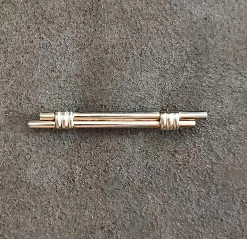 Gold bar pin with double-scroll ridged sections, polished central rod