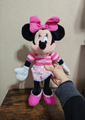 Pink Minnie Mouse plush doll with large pink bow, striped shirt, and pink skirt