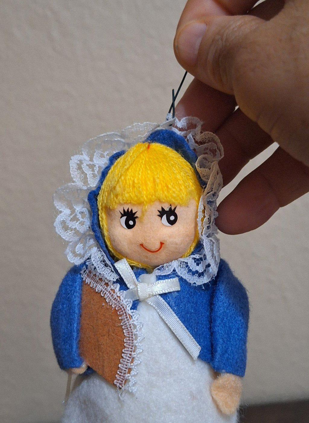 Handmade pilgrim girl ornament figurine with blue bonnet, lace collar, and white apron