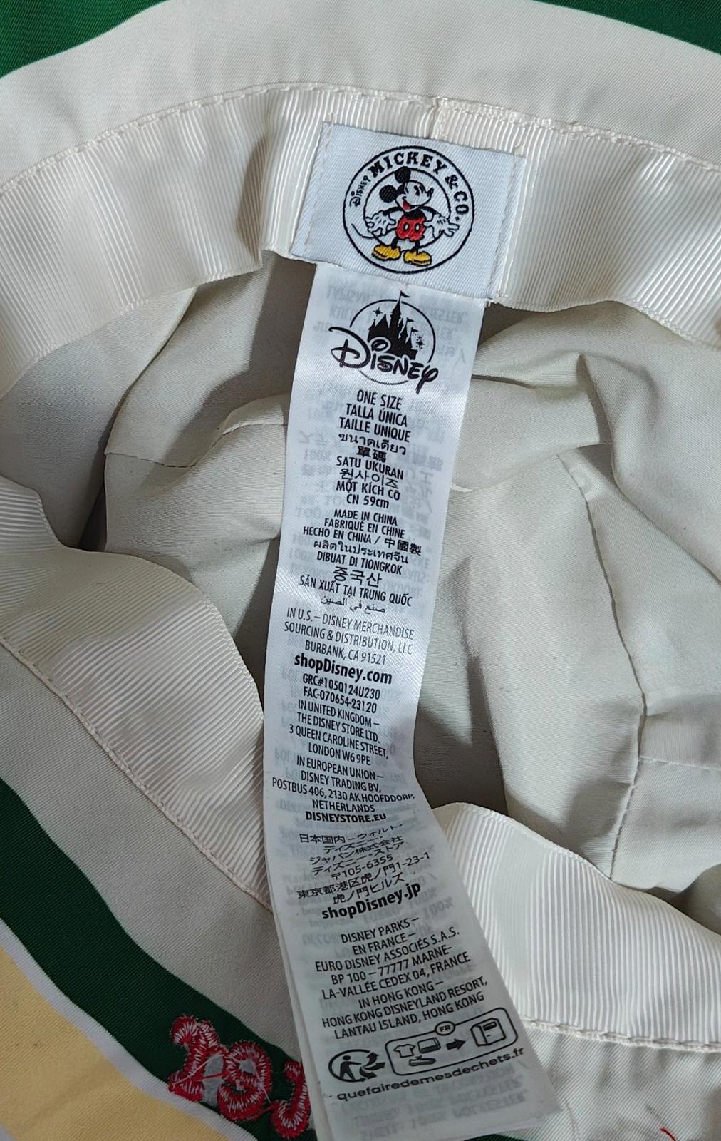 Bucket hat inside tag and care label on white lining, with Disney Mickey crest