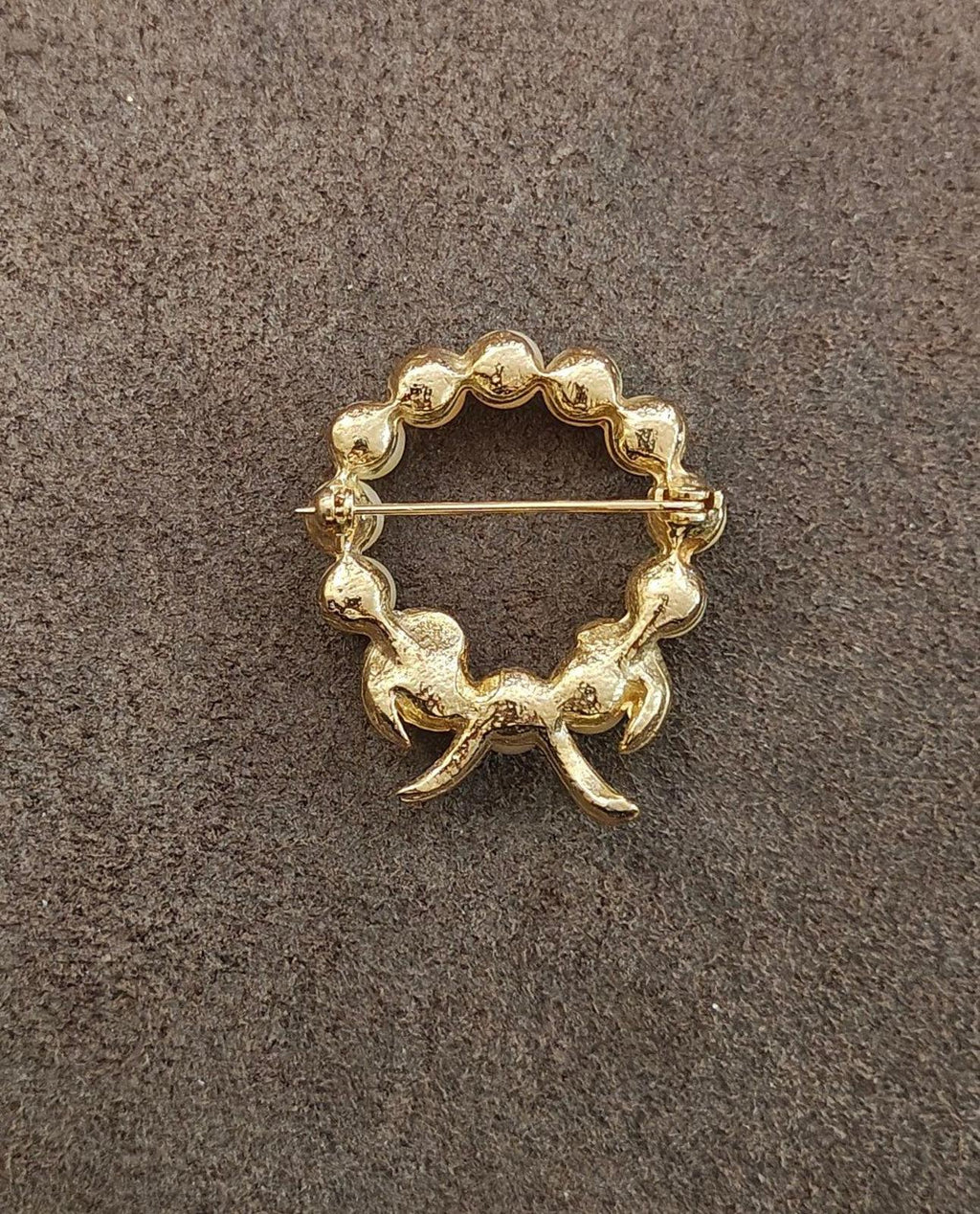 Gold-tone pin back of wreath bow brooch with decorative wreath frame
